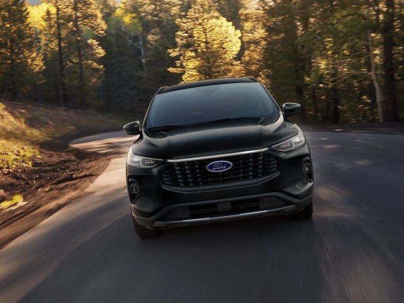 Front view of Ford Escape driving through scenic wood road from Ford Dealer near Me
