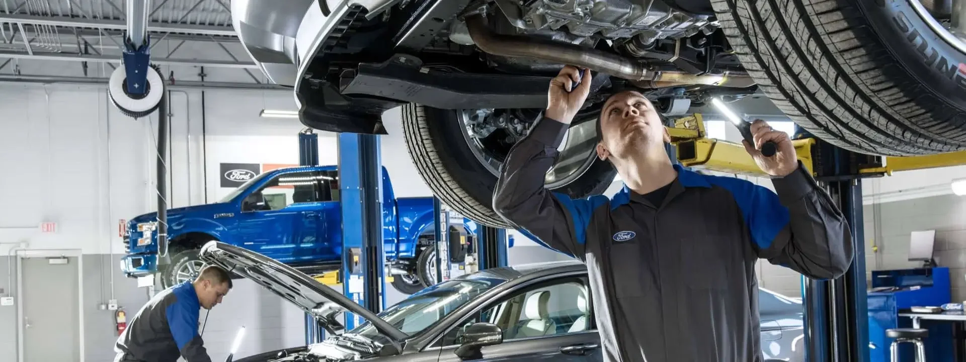 Technician looking at underside of car