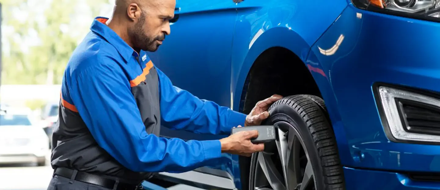 Quick Lane technician checking tire pressure