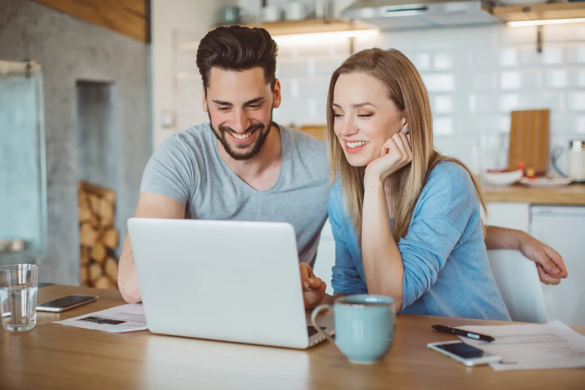 Young couple looking at computer with documents