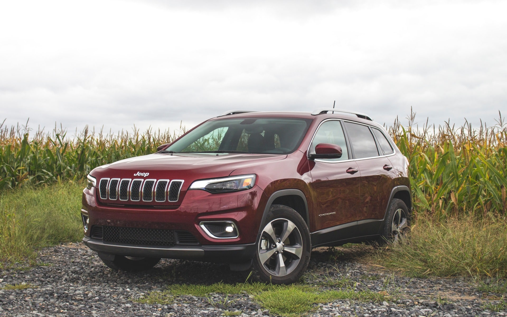 2019 Jeep Cherokee exterior shot with red paint color driving through a suburban downtown city