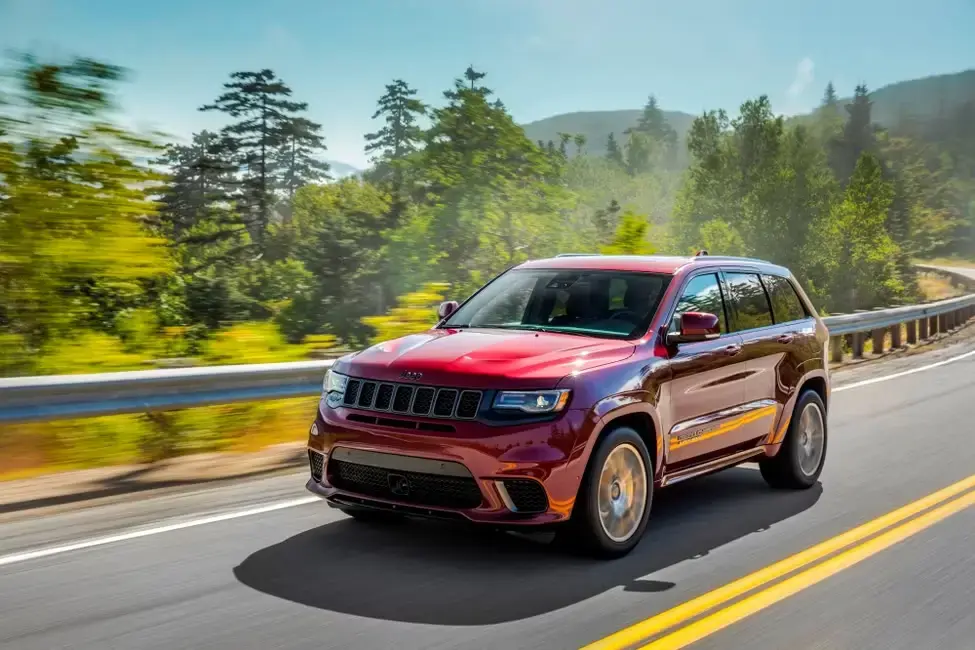 2019 Jeep Grand Cherokee Trailhawk exterior shot with red pain color parked on a race track at sunset