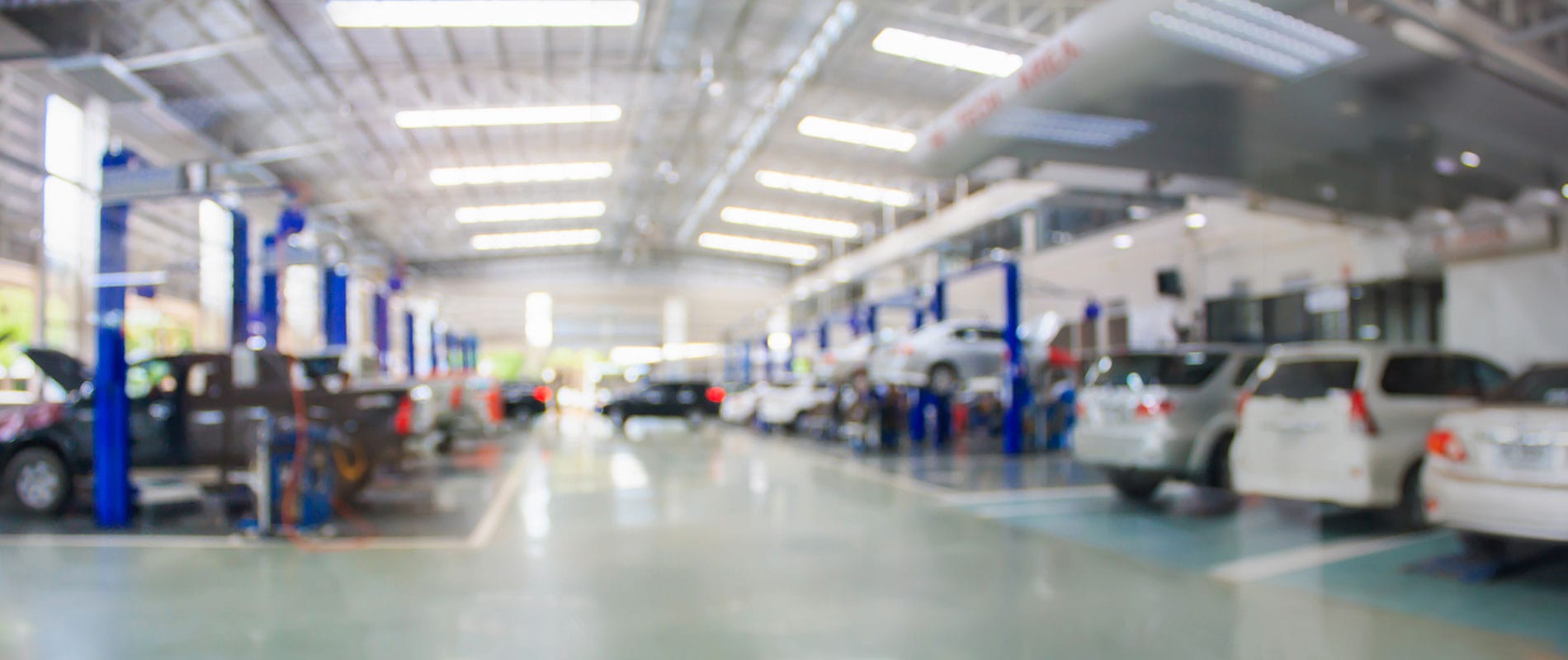 A blurry panoramic image of a vehicle service center.
