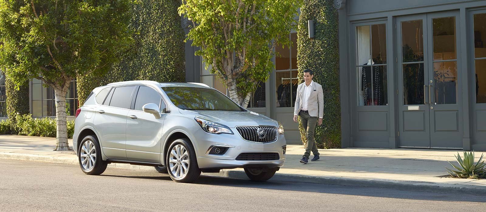 Guy walkig out of our used car dealership towards his buick suv