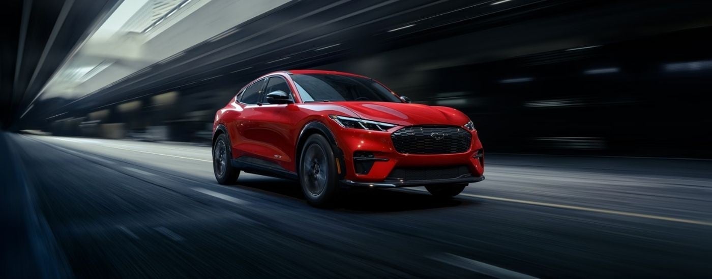 Red 2026 Ford Mustang Mach-E driving through a tunnel