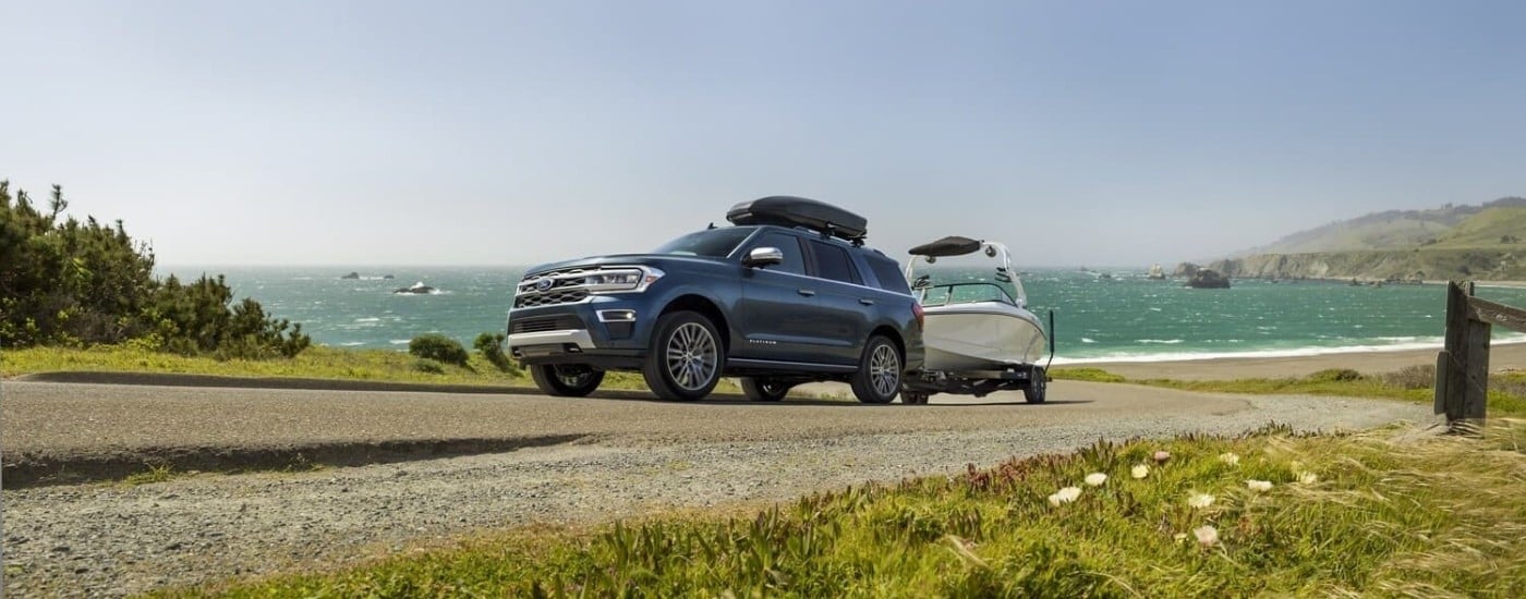Blue 2024 Ford Expedition Platinum towing a oboat