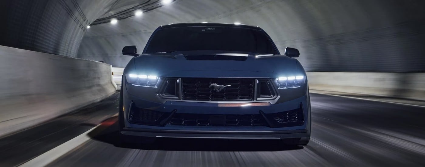 Blue 2025 Ford Mustang Dark Horse driving to a Ford dealer