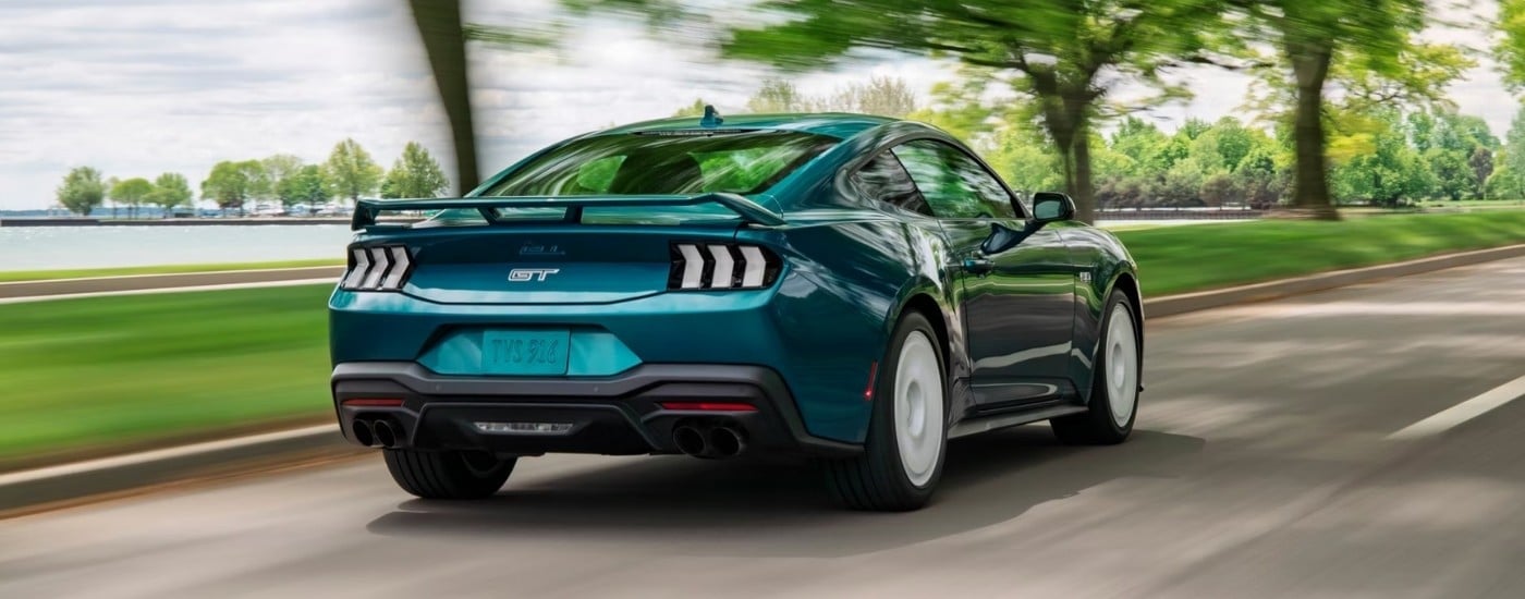 Teal 2026 Ford Mustang GT driving to a Ford dealer near Clermont