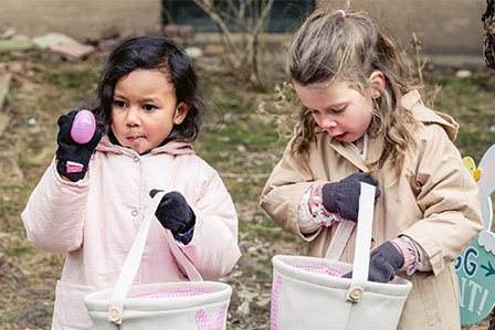 Two children enjoying an Easter egg hunt on Long Island, NY.