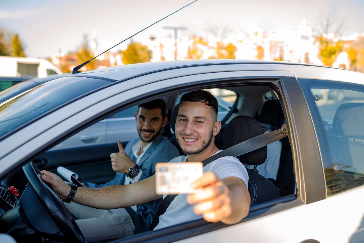 Young man showing off his new drivers license
